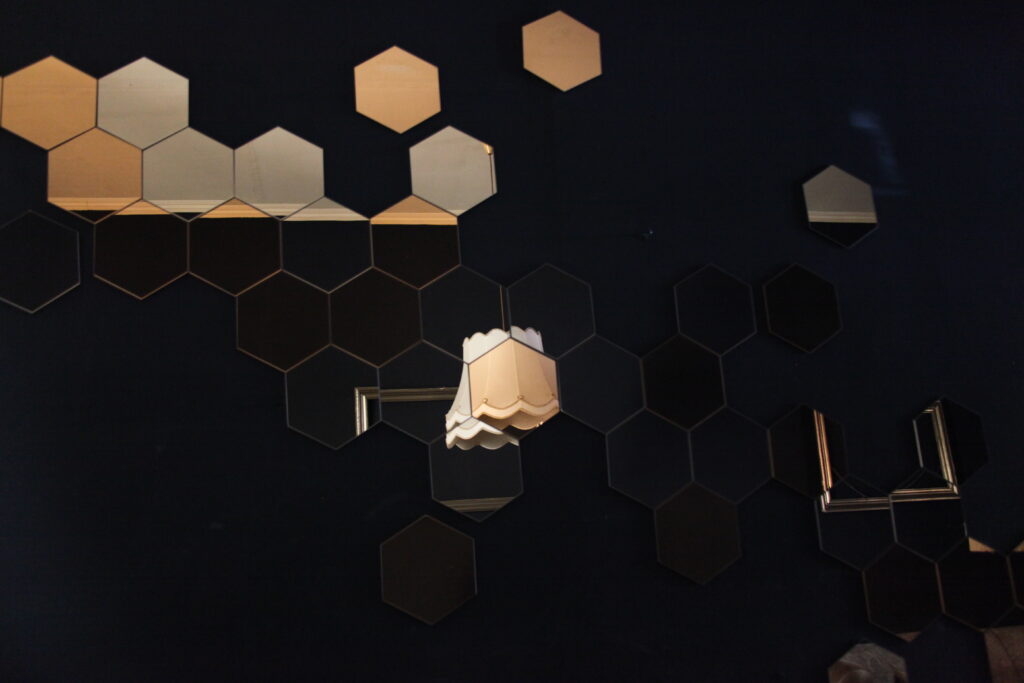 eine schwarze Wand mit Hexagon Spiegeln