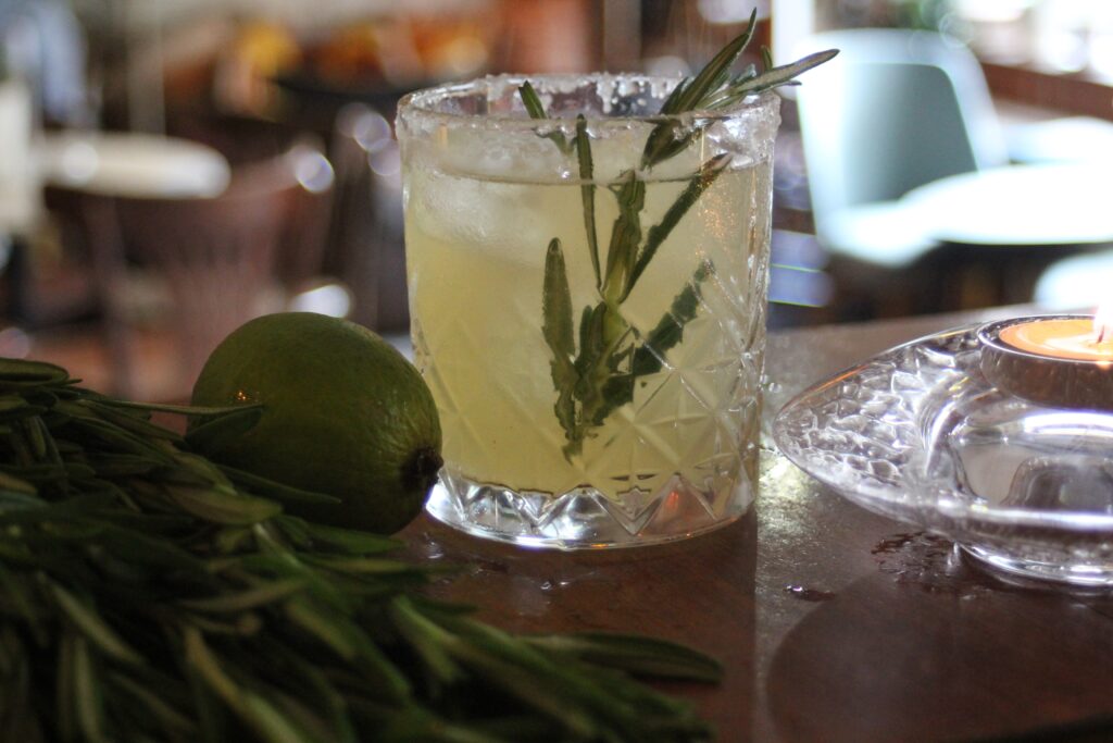 Cocktail im Thumbler daneben eine Limette