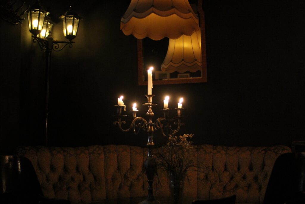 dunkle Ecke mit Sofa und brennender Kerzenleuchter an der Wand eine Straßenleuchte